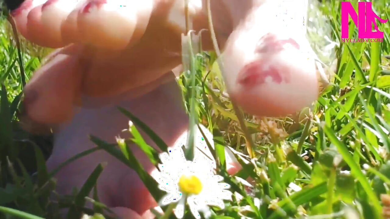 Nyllady loopt op blote voeten op Th Grass in een park
