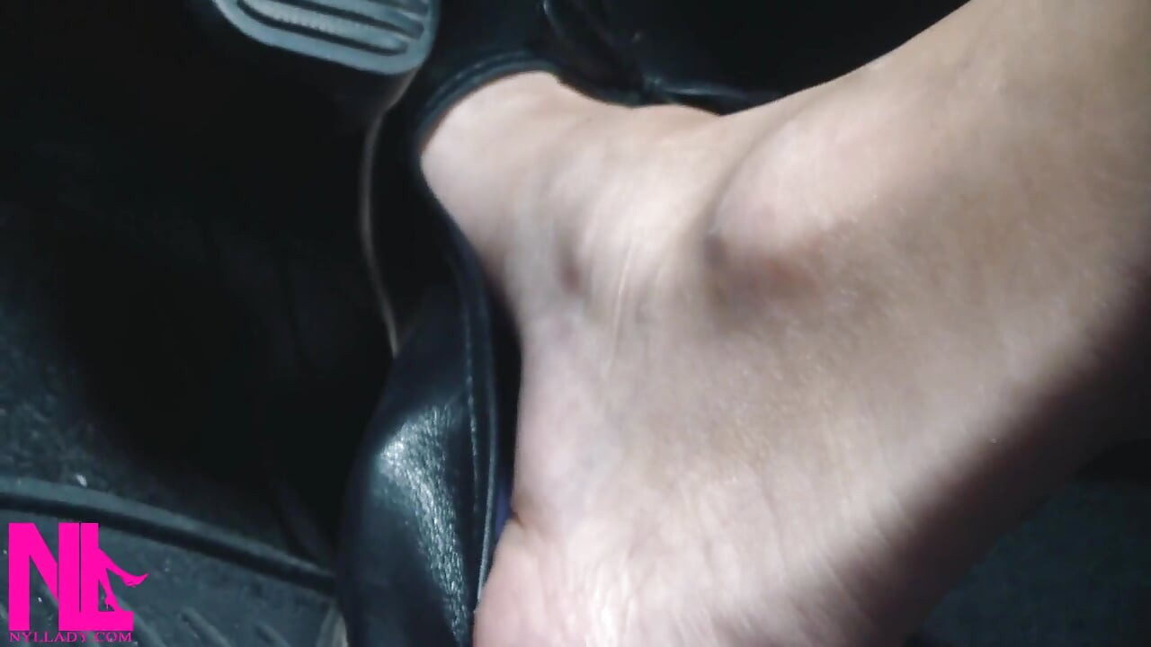 赤腳穿著黑色皮革平底鞋加速和駕駛