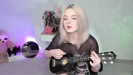 Gorąca blondynka gra na ukulele i śpiewa w niegrzecznym stroju