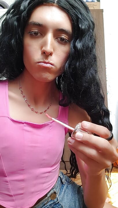 Cute shemale girl sucks the bottle of deodorant after applying lipstick