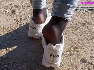 Девушка в тапочках Fila Destrudor играет с обувью в нейлоновых ступнях и толчках