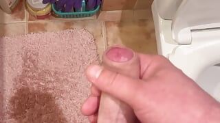 Junger Kerl masturbiert in der Toilette und Nahaufnahmen seines großen und Kopfes