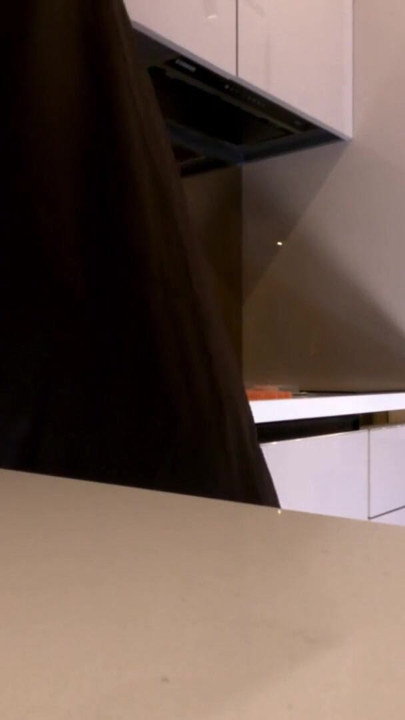 Quente sexy esposa morena de pernas longas em meias arrastão preta e vermelha com uma camisinha de cetim provoca na cozinha | Clipe 1