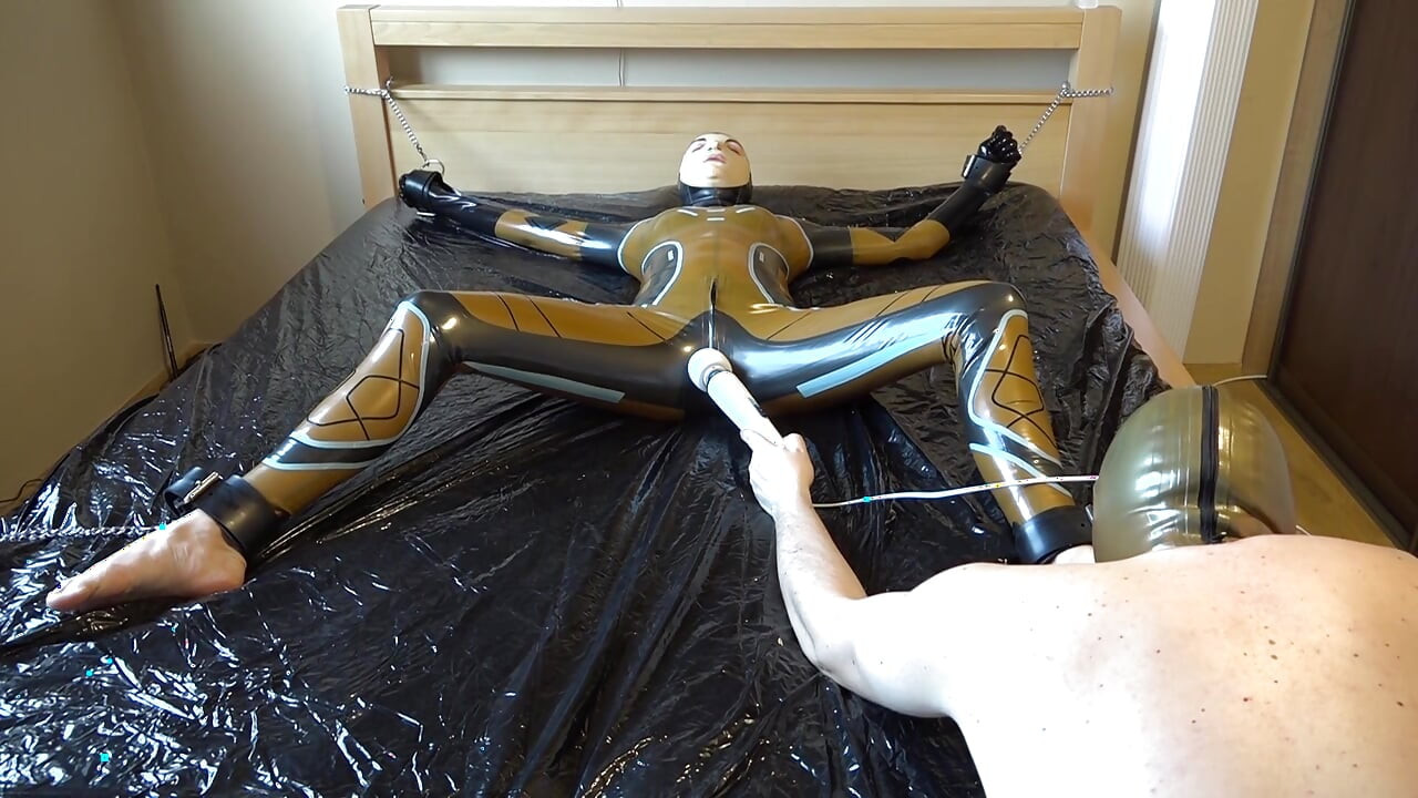 Latex Danielle is attached to the bed and masturbated with the massage vibrator