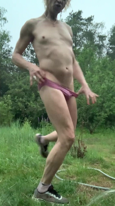 Trans-girl Alexa Cosmic soaking wet in summer rain and getting nude and playing water hose | Clip 1