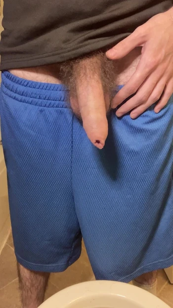 Hairy uncircumcised white guy in gym shorts pissing in the toilet