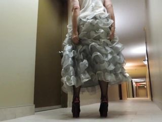Sissy Ray en vestido de noche plateado en el pasillo del hotel