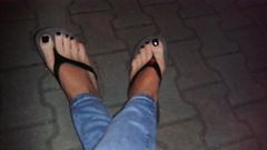glossy black toe nail polish and platform flip flops