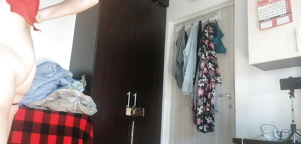 Amatorskie żona tańczy nago w domu. Amatorka ma zabawę przymierzając ubrania i wycinając je.