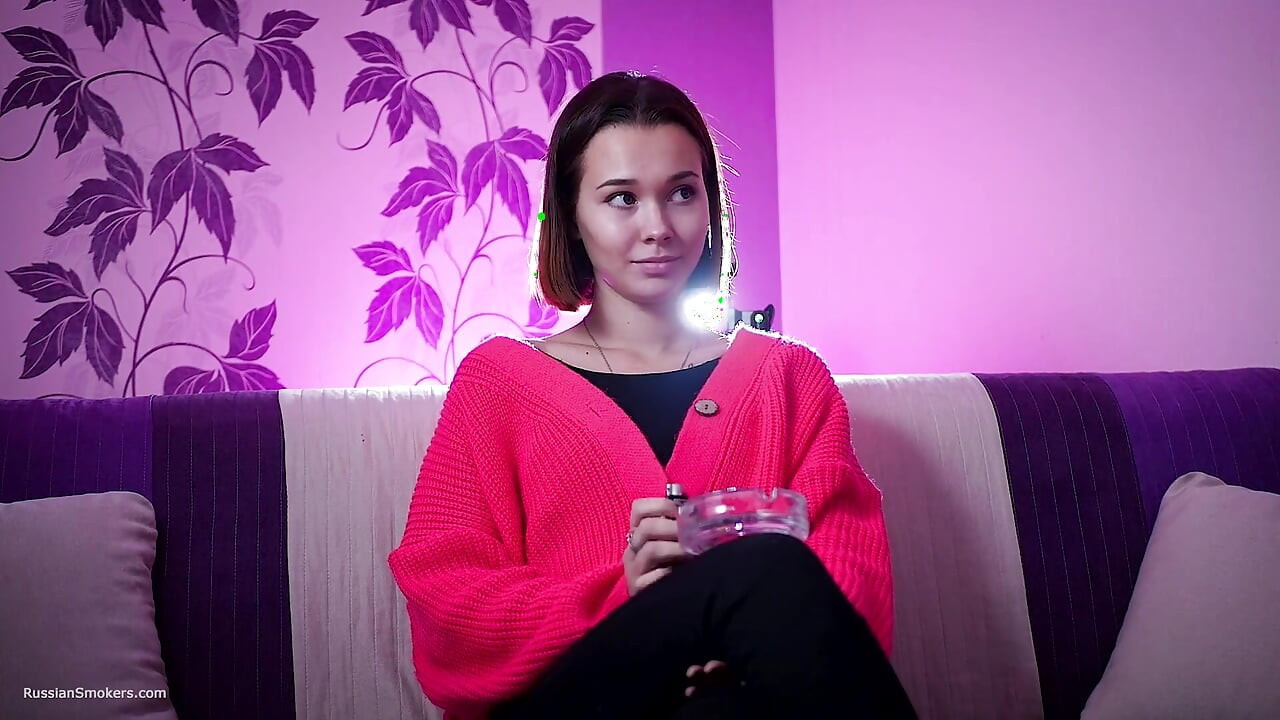 セクシーなロシアのミューズがタバコを吸う 柔らかな昼間
