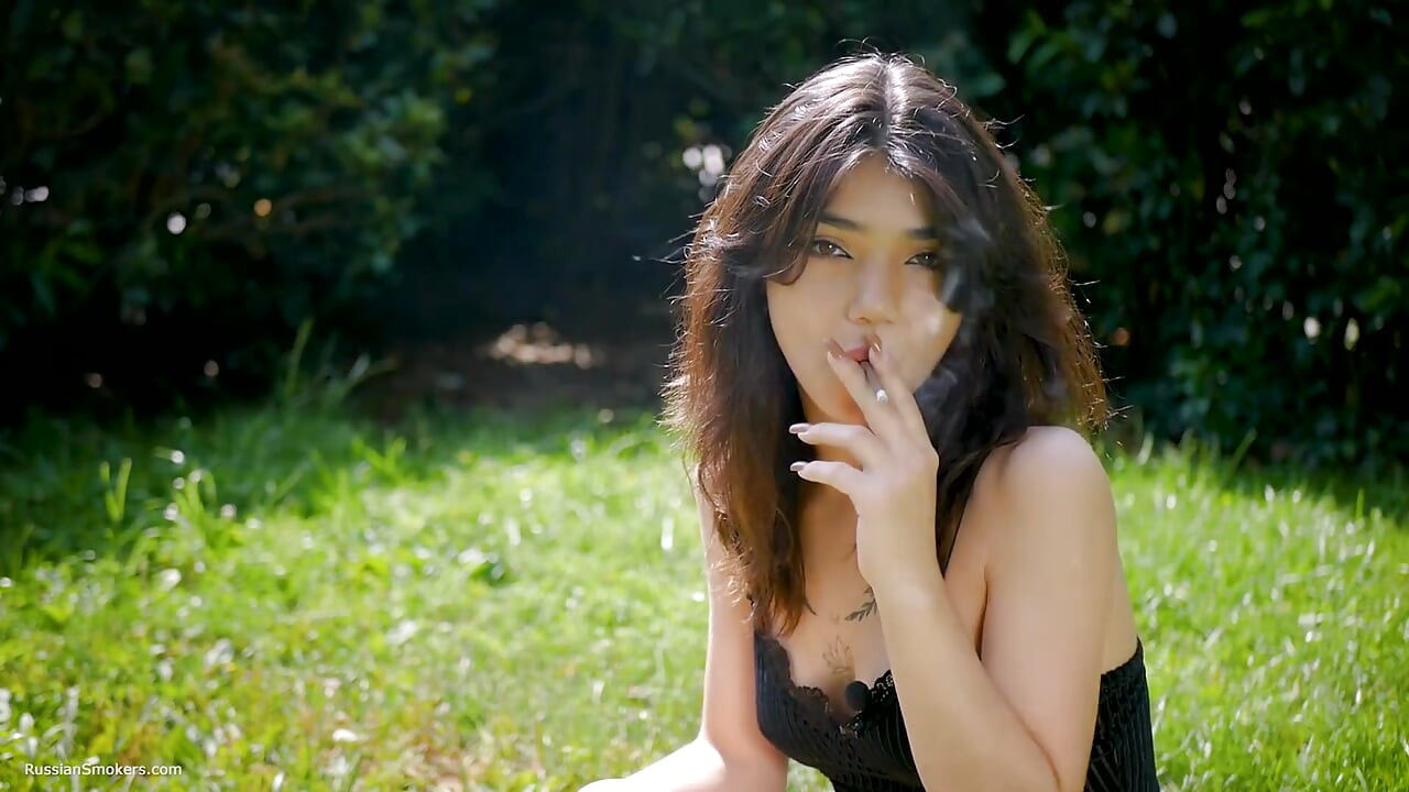 Arina fume une cigarette noire à l’extérieur