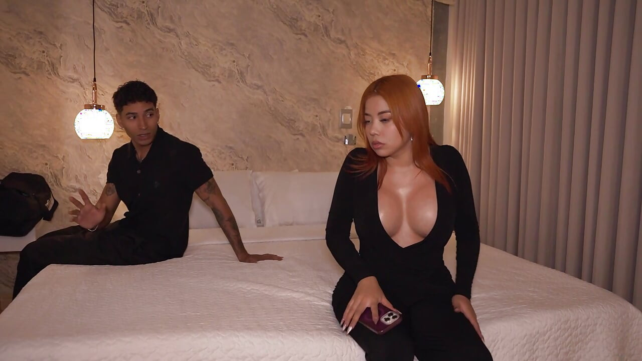 A busty redhead has no choice but to share the same hotel bed with her roommate.