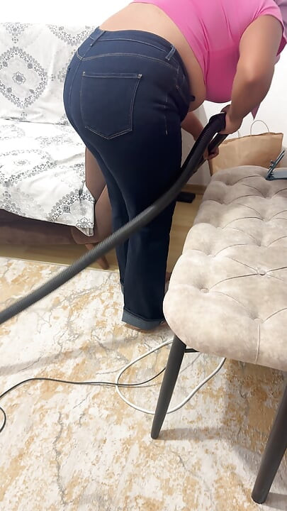 Curvy woman cleaning the house in trousers