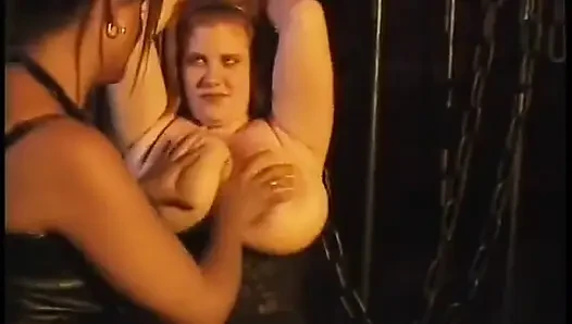 Black mistress plays with bondaged chick's huge jugs
