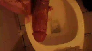 Une grosse bite se fait branler dans les toilettes publiques