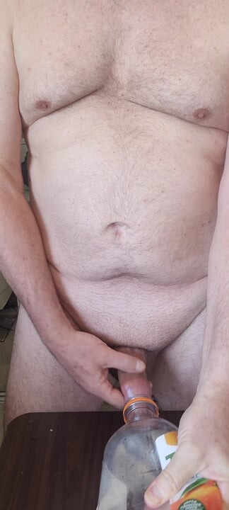 Exhibitionist masturbator testing a new bottle for cock play