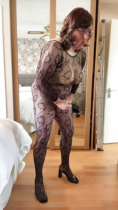 Crossdresser sexy vestindo e a masturbar-se num bodystocking transparente de renda.
