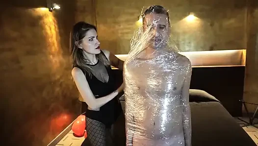 Domina-mädchen steckt ihren sklaven in klebeband-bondage