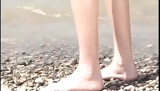 Teen girls are fucking each other with a clear dildo on the beach