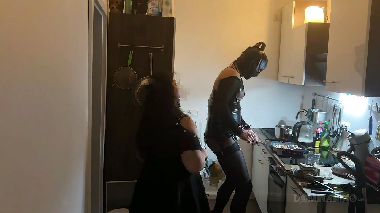 Milf dominante estira el culo del sumiso de látex en la cocina