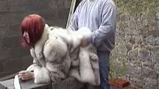 Un mari baise sa femme dans un manteau de fourrure de renard