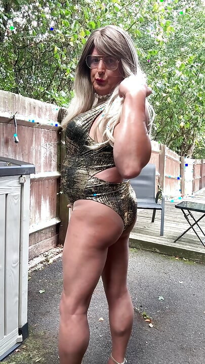 Seksi transvestit kellycd2022 u zlatnom kupaćem kostimu i štiklama čisti lišće