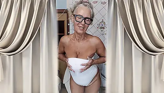 Heiße hausfrau Lukerya flirtet zu hause in ihren weißen dessous.