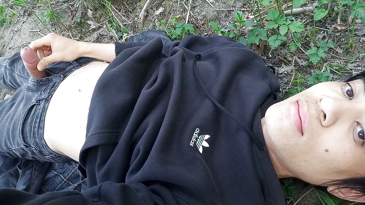 The cute gay twink jerking off his cock, pulled through his fly while outdoors, is Jon Arteen