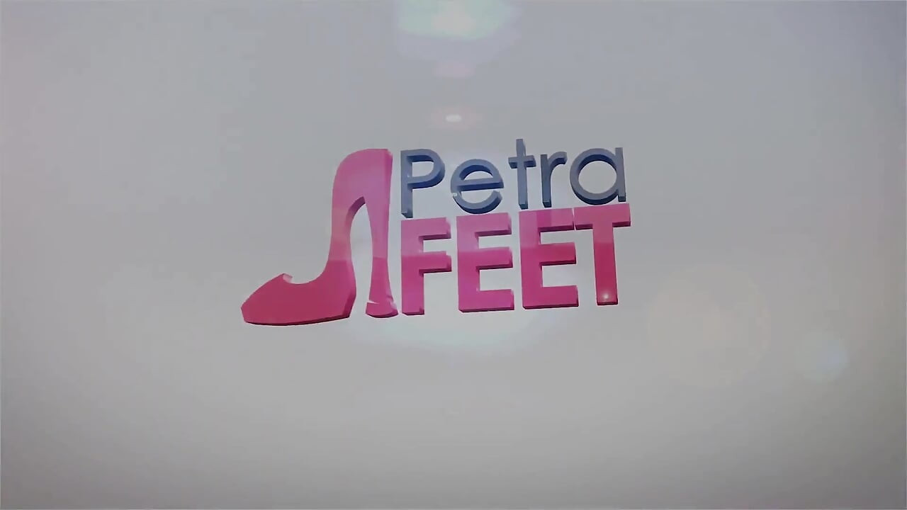 Petra, îmbrăcată în piele, se joacă cu picioarele și fumează