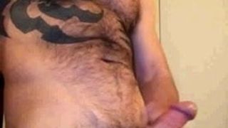 Peludo homem hetero tatuado bombeia uma carga