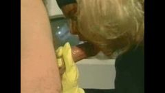 Blondes Mädchen in den Küchen-Latex-Handschuhen