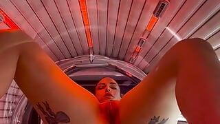Getatoeëerd meisje masturbeert in de zonnestudio
