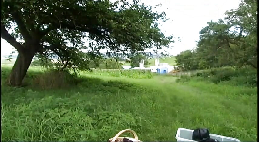 Fetish slave in latex walks and sucks a dildo on the grass