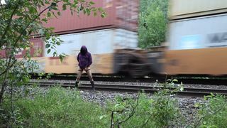Shy transgender flashing by train tracks