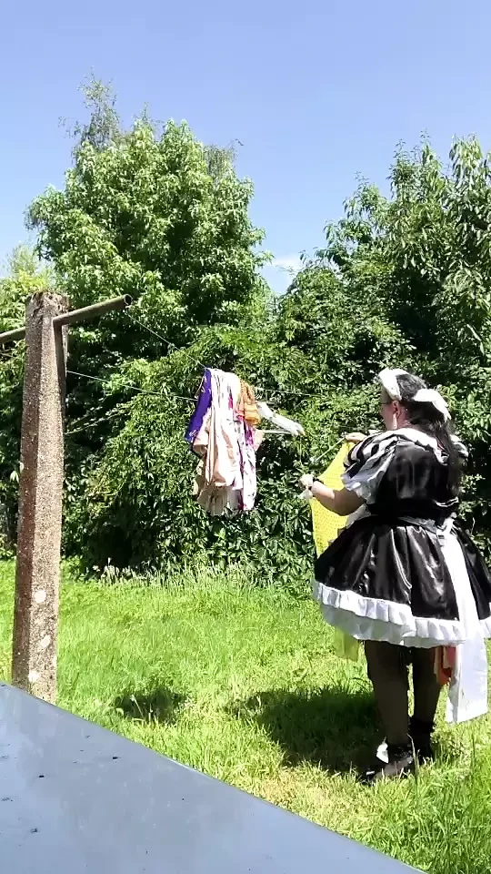 In a black and white maid outfit to hang out the laundry.