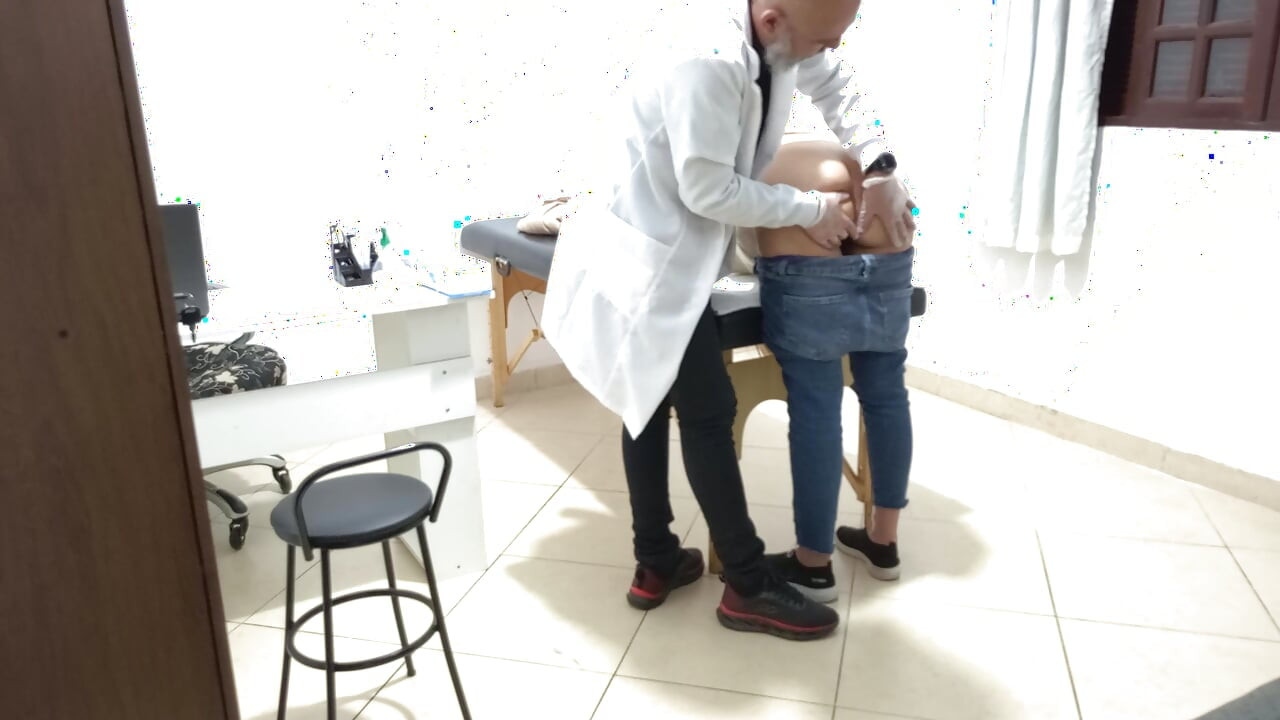 Proctologist performs anal exam on constipated patient.