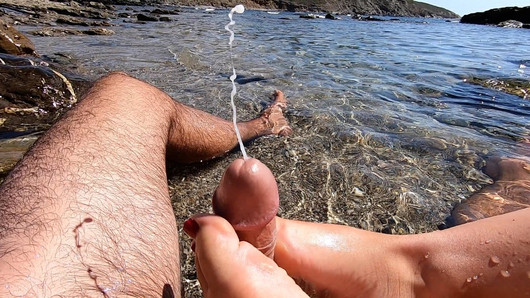 Footjob amateur avec éjaculation en plein air sur une plage publique