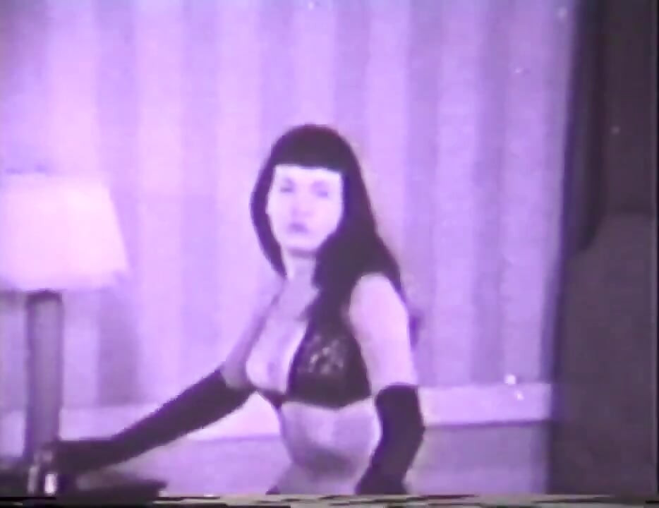 Chica vintage con peinado anticuado se quita la lencería sexy