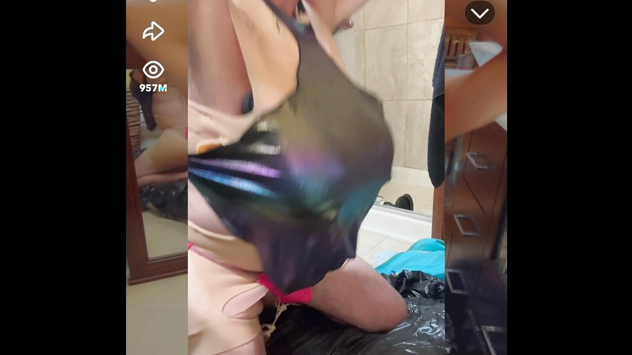 Sexy shemale wears shiny metallic halter top while masturbating