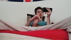 Twink jerks off his big cock and ejaculates while watching a porno
