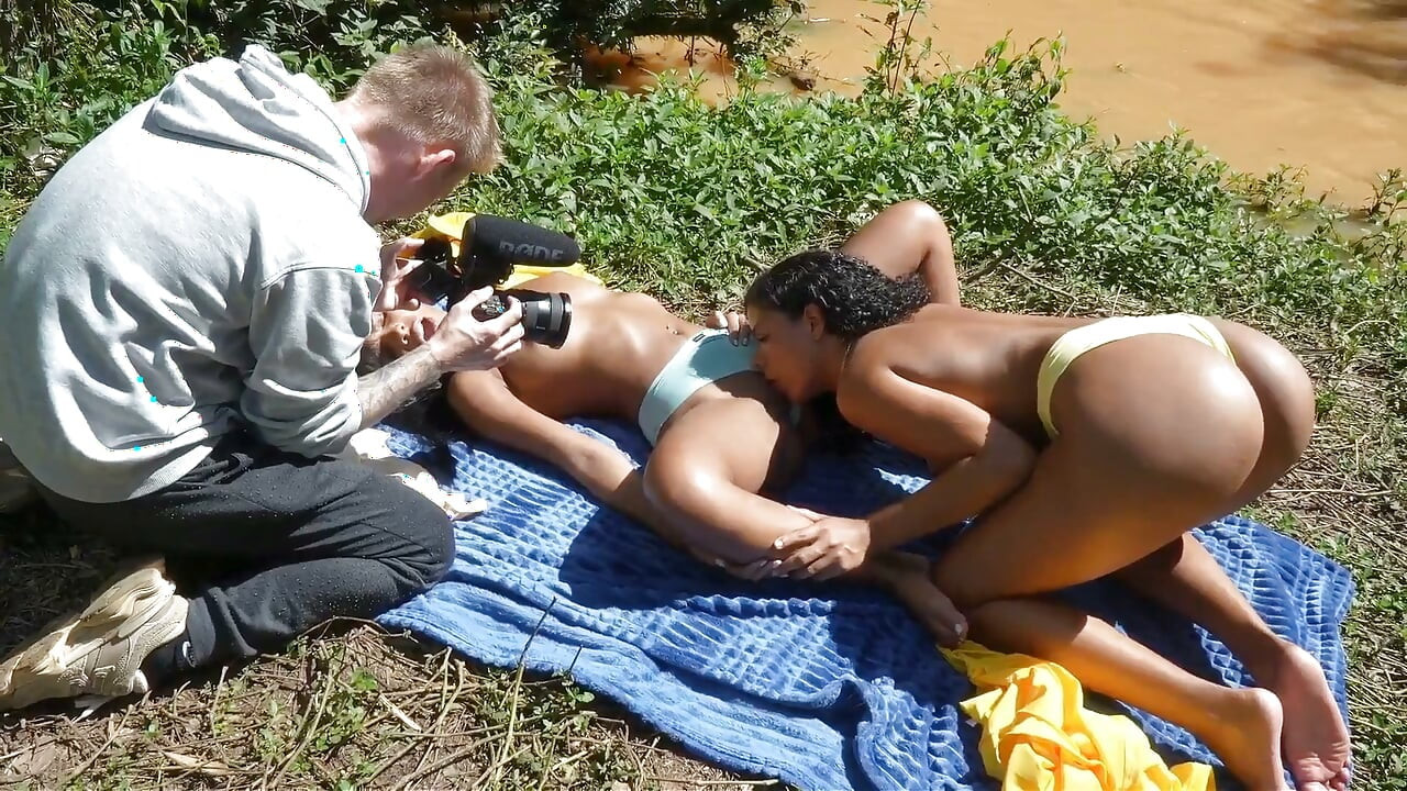 Nos bastidores das filmagens, duas latinas de pele escura se deleitam com a natureza