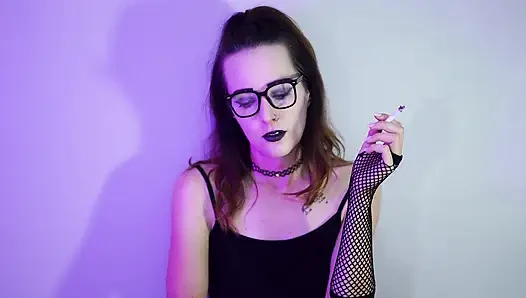 Goth-mädchen raucht in netzstrümpfen