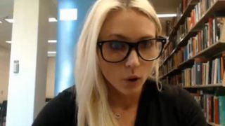 Симпатичная блондинка студентка светит в библиотеке