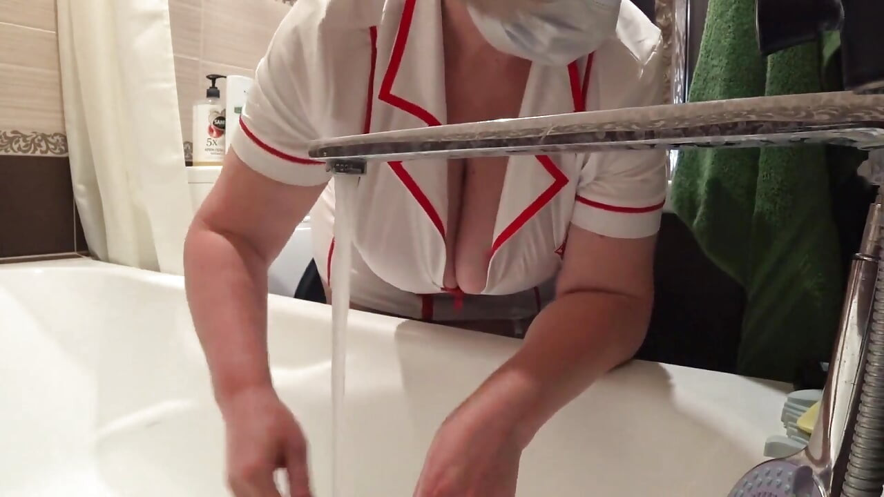 Big Boobs. Gorgeous Cleavage Under a Medical Gown. a Mature Nurse on Camera at Work