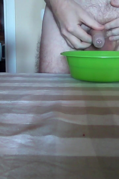 ジョンはテーブルの上の緑色のボウルにおしっこをしています