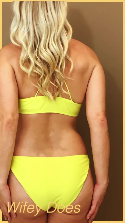 妻子穿着一个略微的黄色比基尼