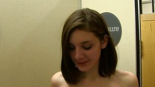Brunette in kleedkamer grijpt naar haar borsten.