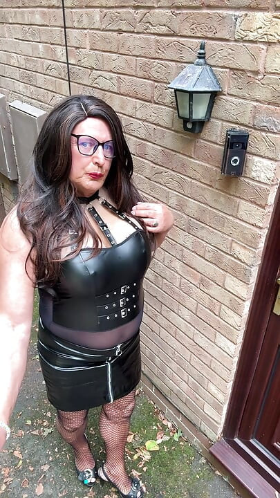 Seksi transvestit kellycd2022 u crnom PVC bodiju i mrežastim čarapama i štiklama