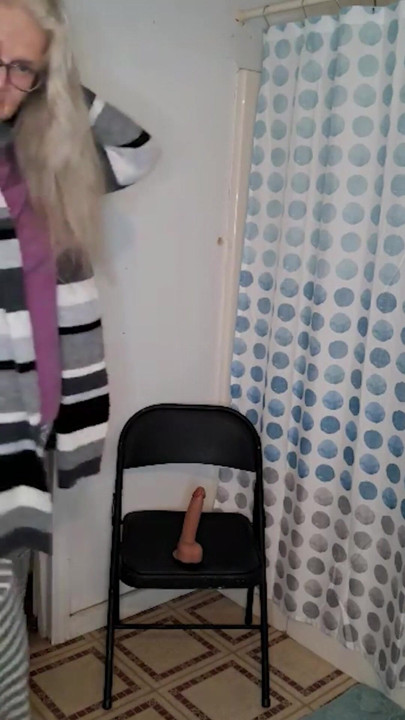Ateşli orta yaşlı seksi kadın sandalyede dildosunu sikmeye çalışırken sorun yaşıyor! | Klip 1