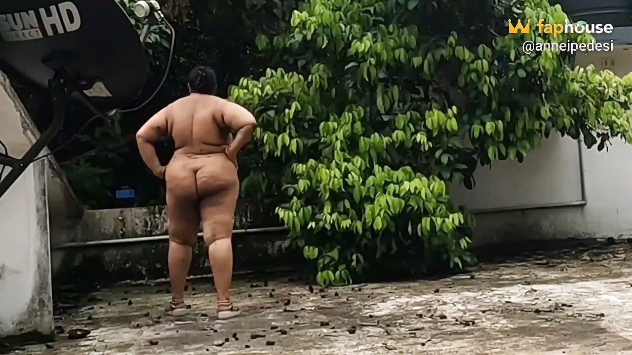Nudista traviesa de La India relajarse al aire libre desnuda, comiendo fruta fresca y disfrutando